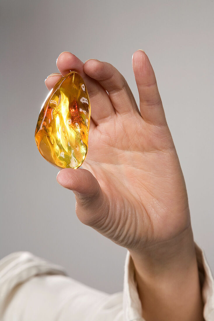 Обработанный янтарь в женской руке